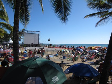 People stake out their spots to view a 60-foot movie screen set up on Waikiki Beach.