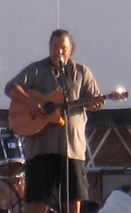 Willie K plays a guitar  and sings onstage.